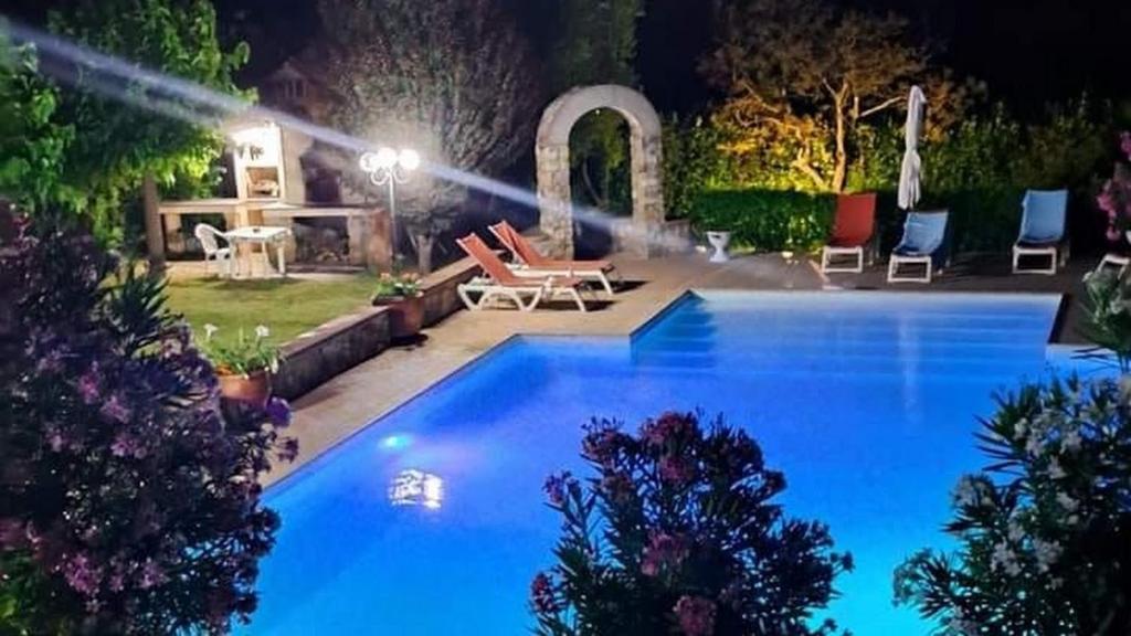 - une grande piscine dans un jardin la nuit dans l'établissement Nido Del Merlo, à Santomato 