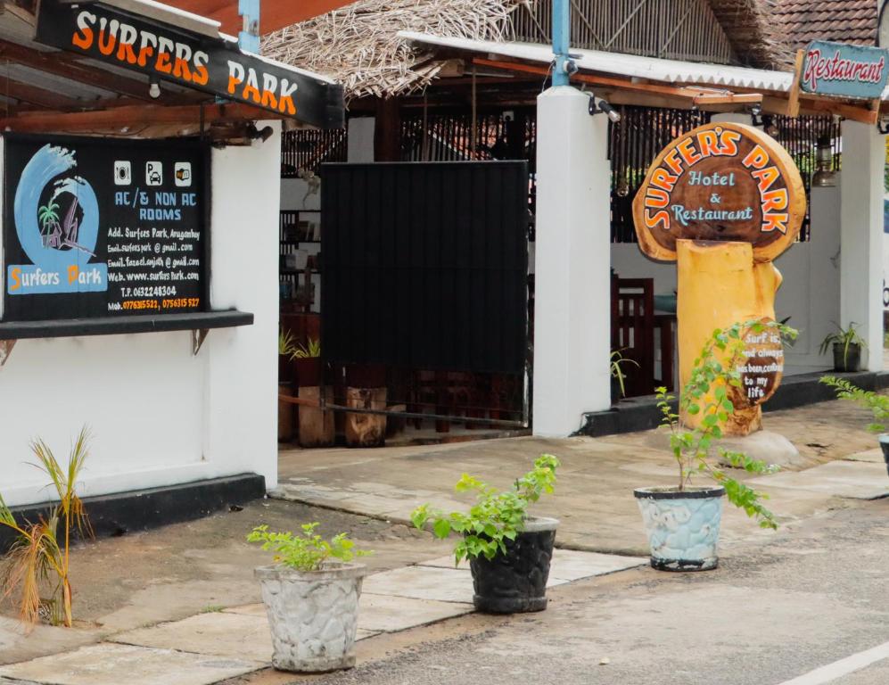 a restaurant with potted plants in front of a building at Surfers Park Arugambay in Arugam Bay