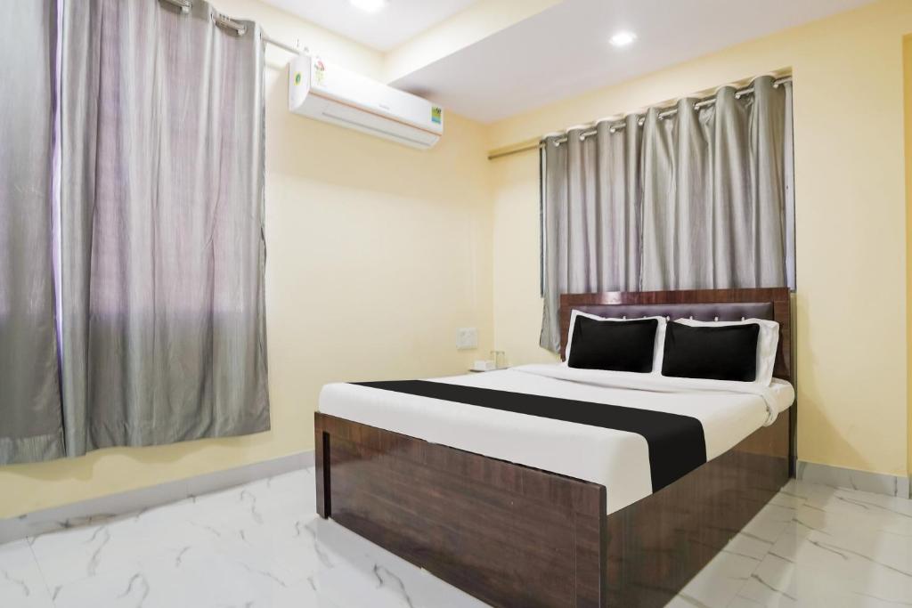 - une chambre avec un grand lit et une fenêtre dans l'établissement OYO Hotel Bluebird Inn, à Nagpur