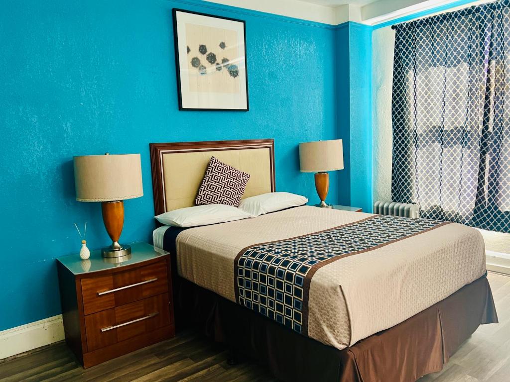 a bedroom with a bed with blue walls and two lamps at Admiral Hotel in San Francisco