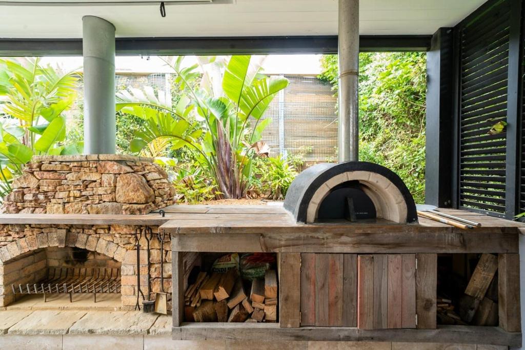 a wood fired oven sitting on a patio at Stylish Beach Home - Moments from Water in Terrigal