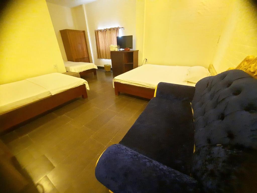 uma sala de estar com duas camas e um sofá em RUBY Cà Mau em Cà Mau