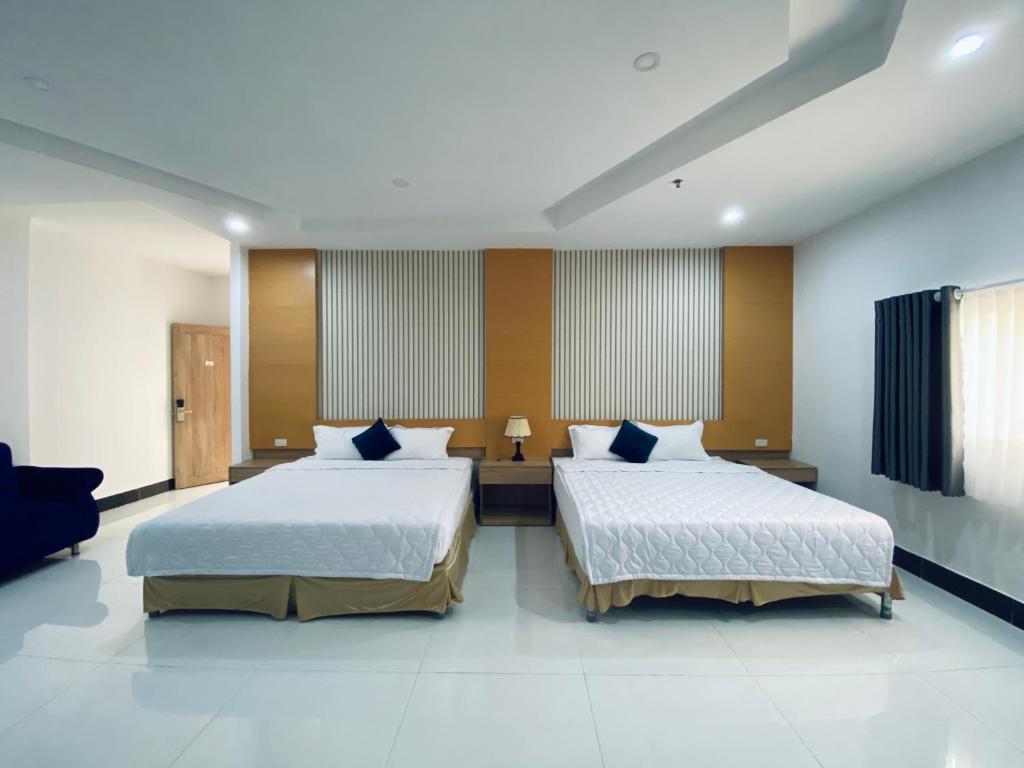 two beds in a large room with two beds sidx sidx sidx at Miền Tây Hotel in Can Tho