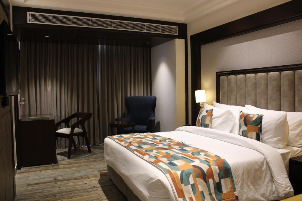 Pokój hotelowy z dużym łóżkiem i biurkiem w obiekcie BluSalzz Residence Amritsar w mieście Amritsar