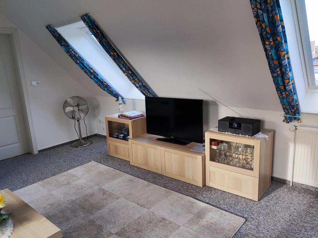 sala de estar con TV de pantalla plana en un soporte en Ferienwohnung Arff, en Rendsburg