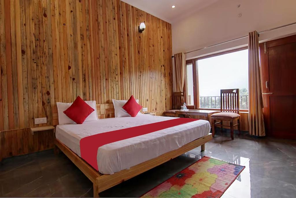 Schlafzimmer mit einem Bett mit roten Kissen und einem Fenster in der Unterkunft Goroomgo Wooden Umbrella Bhimtal - Natural landscape Mountain View in Bhīm Tāl