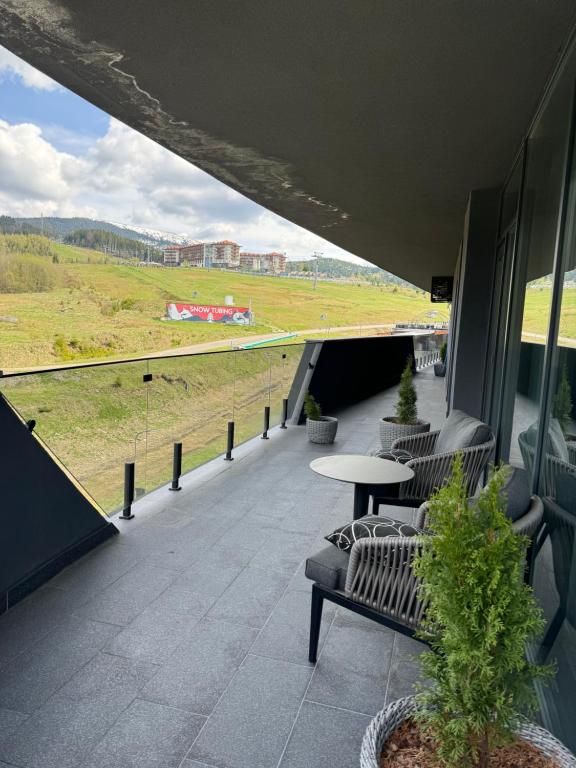 a balcony with a table and chairs on a building at SAVOIE Apartments Bukovel in Bukovel