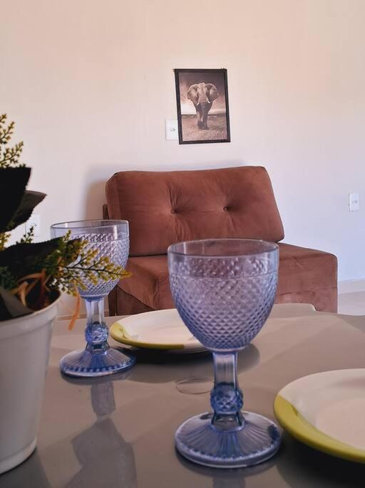 dos copas de vino azul sentadas en una mesa en Flat ideal para familia e grupos de amigos proximo ao aeroporto e rodoviária, en Palmas