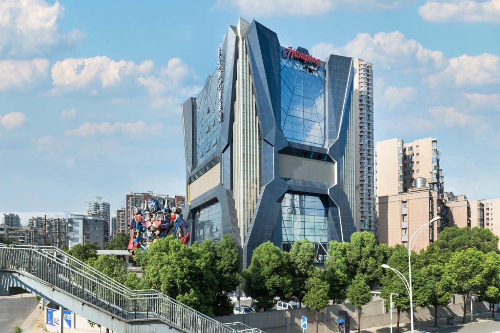 een hoog gebouw met een bord aan de zijkant bij Hampton by Hilton Wuhan Zhongnan Jiedaokou Hotel in Wuhan