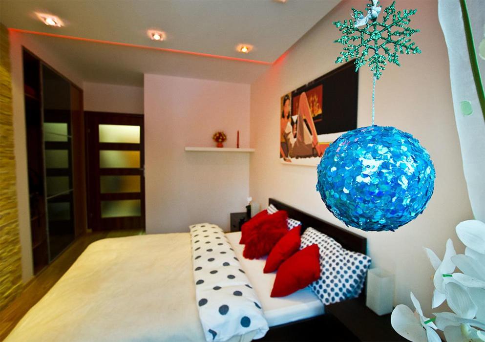 a bedroom with a bed with red pillows and a blue ball at Apartament Cicha Woda Zakopane in Zakopane