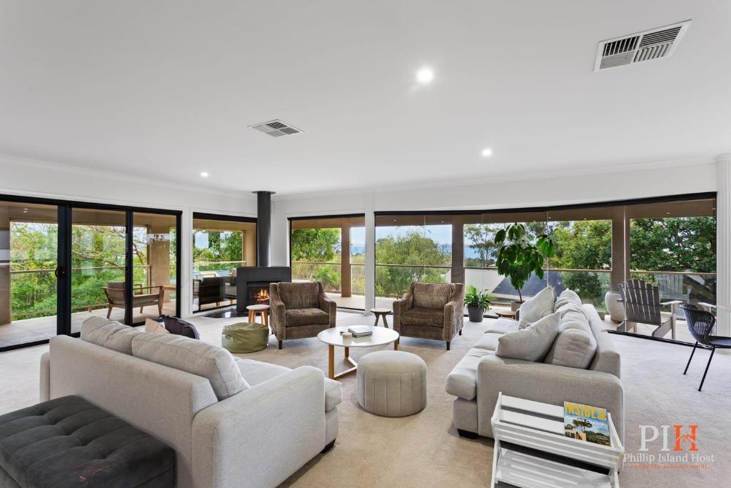 a large living room with white furniture and glass windows at Spacious Retreat with Coastal Views in Cowes