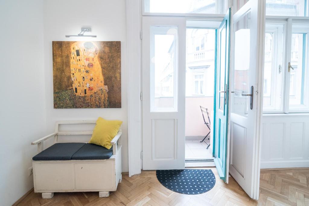 a room with a bench and a painting on the wall at NewSunny Apartment at the BudaCastle in Budapest