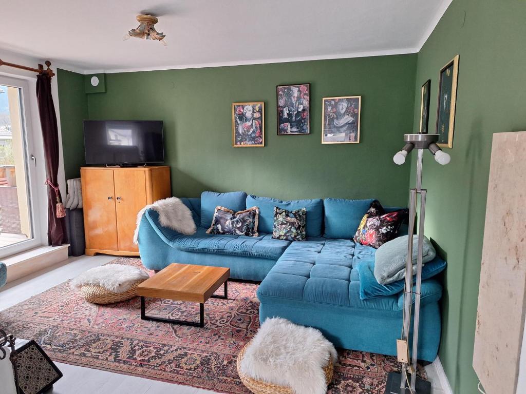 sala de estar con sofá azul y TV en Ferienwohnung "Josefine und Ihr Kavalier", en Kundl