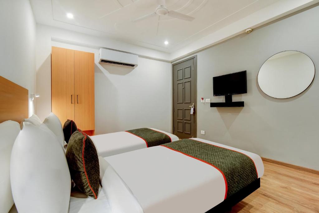 Habitación de hotel con 2 camas y espejo en Townhouse 219 en Gurgaon