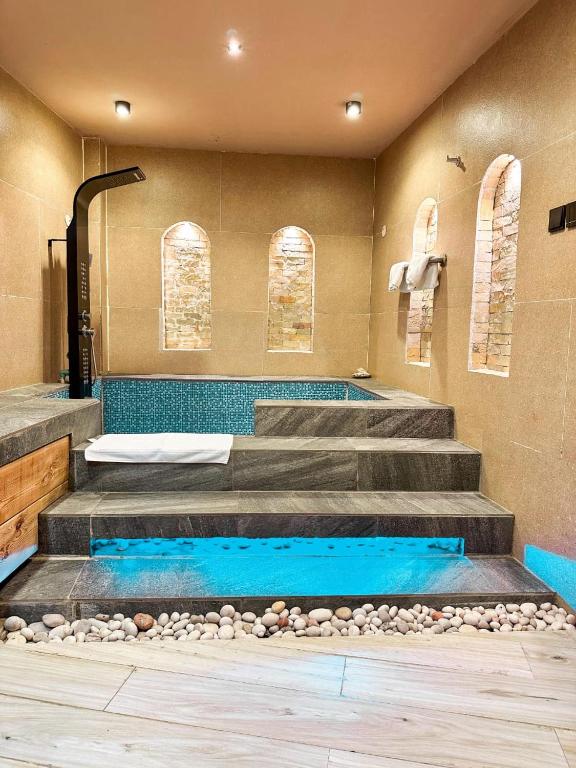 un bagno con vasca e scale con doccia di Omani Guest House نزل البيت العماني a Nizwa
