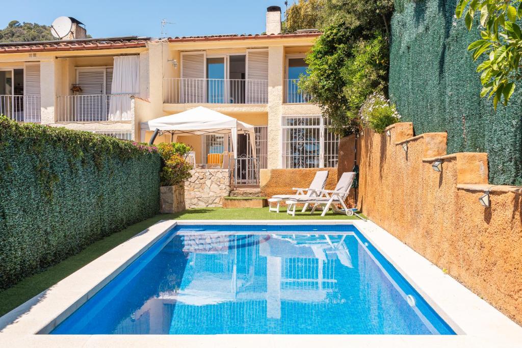 une villa avec une piscine et une maison dans l'établissement Villa Frente al Mar, à Tossa de Mar
