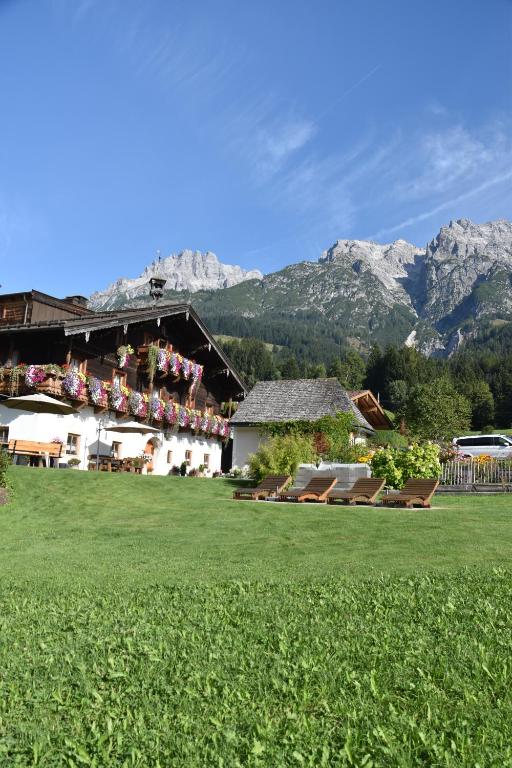 budynek z zielonym trawnikiem z górami w tle w obiekcie Brandstatthof Leogang w mieście Leogang