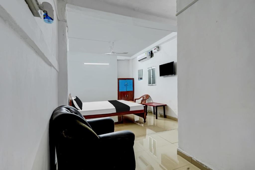 OYO Flagship Hotel Shiv Residency في رانشي: غرفة نوم بسرير واريكة في غرفة