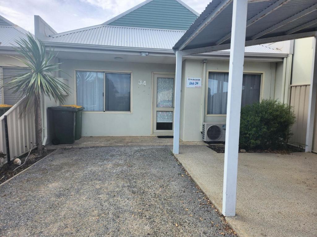 a house with a blue roof and a driveway at Unit 34 Seafront Estate in Jurien Bay
