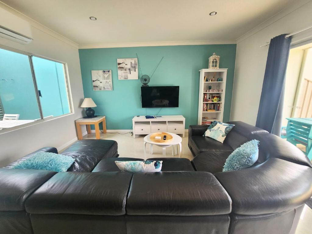 a living room with a leather couch and a tv at Unit 34 Seafront Estate in Jurien Bay