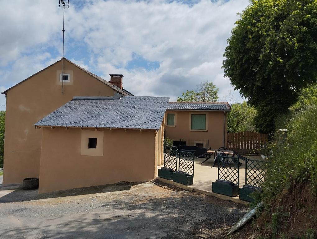 una pequeña casa con techo y valla en Gite Le Lucimond, en Saint-André