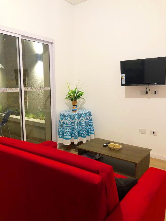 a living room with a red couch and a table at Copacabana’s House Microcentro in Salta