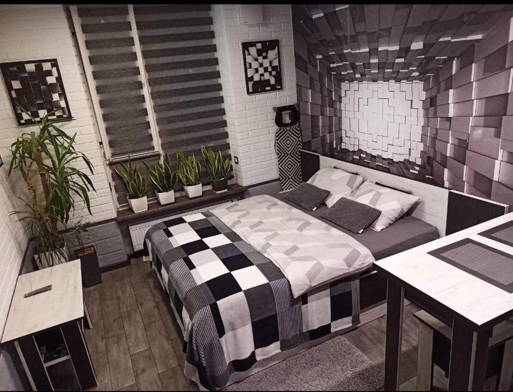 ein Schlafzimmer mit einem Bett in einem Zimmer mit Pflanzen in der Unterkunft Wiew Lux Studio Apartments in a Secure Residential Complex Comfort Town КТ-03 in Kiew