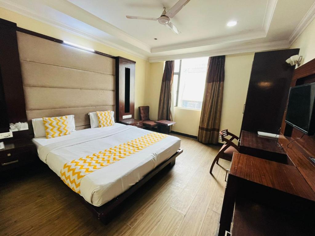 a hotel room with a large bed and a desk at Hotel Imperial Inn - Nehru Enclave in New Delhi