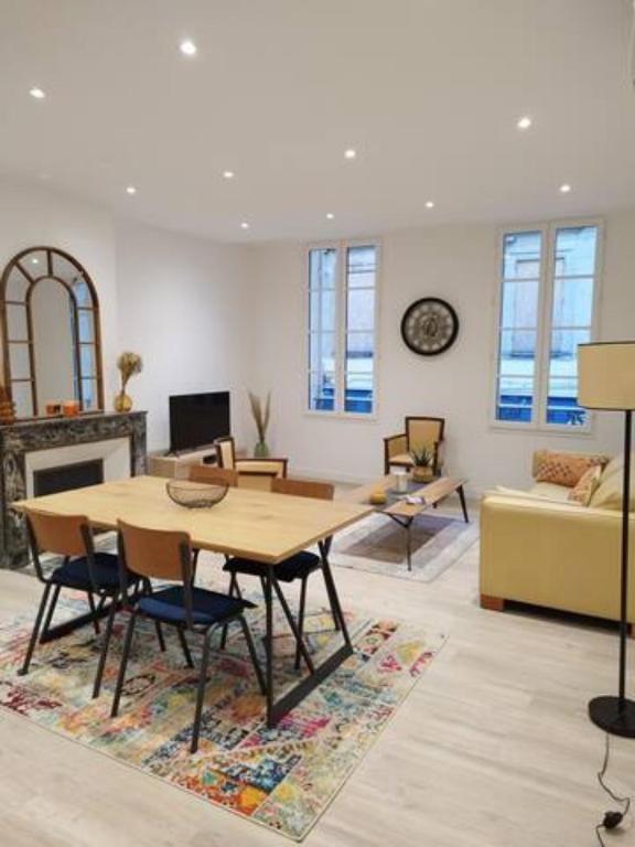 un salon avec une table et un canapé dans l'établissement Appartement neuf en plein cœur de la Bastide, à Libourne