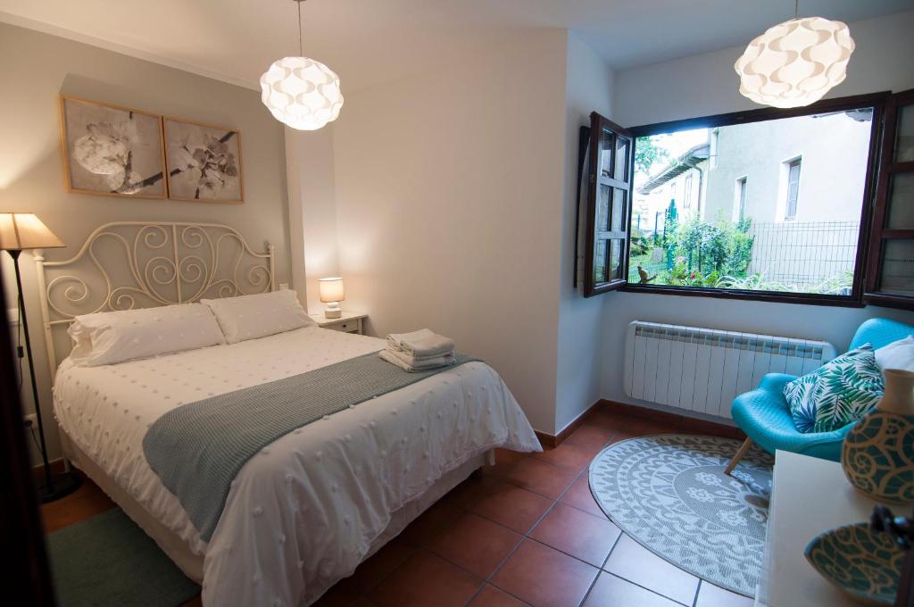サンティリャーナ・デル・マルにあるLa Casa de Mariaのベッドルーム1室(ベッド1台、窓、椅子付)