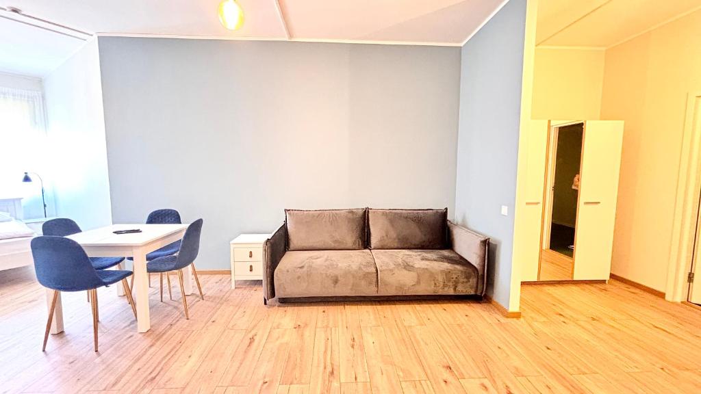 a couch in a living room with a table and chairs at Kastanimaja Apartments in Tartu