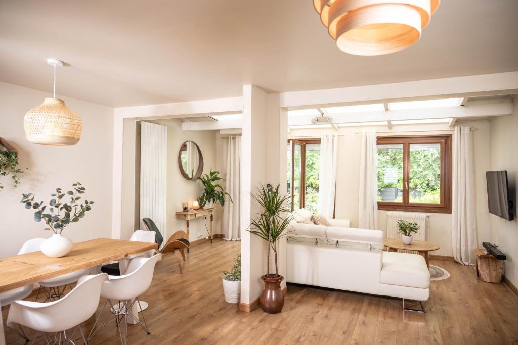 uma sala de estar com um sofá branco e uma mesa em Belle maison lumineuse et paisible em Reims