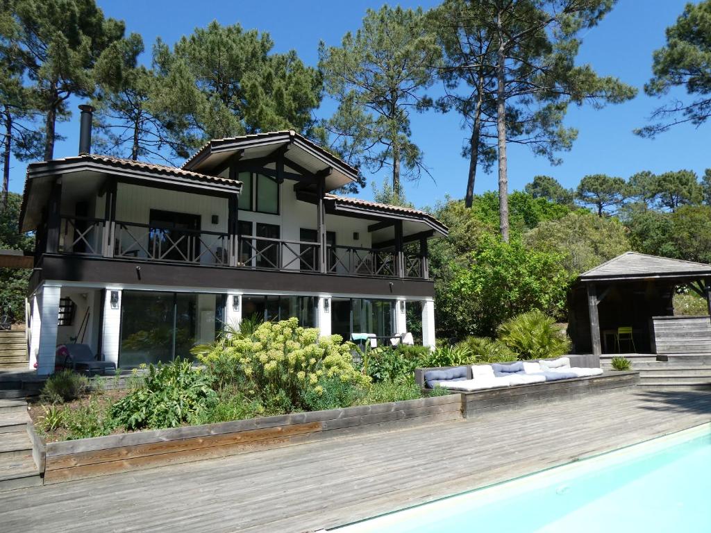 une maison avec une piscine devant dans l'établissement Entre Océan et Lac, vue sur le golf, à Lacanau