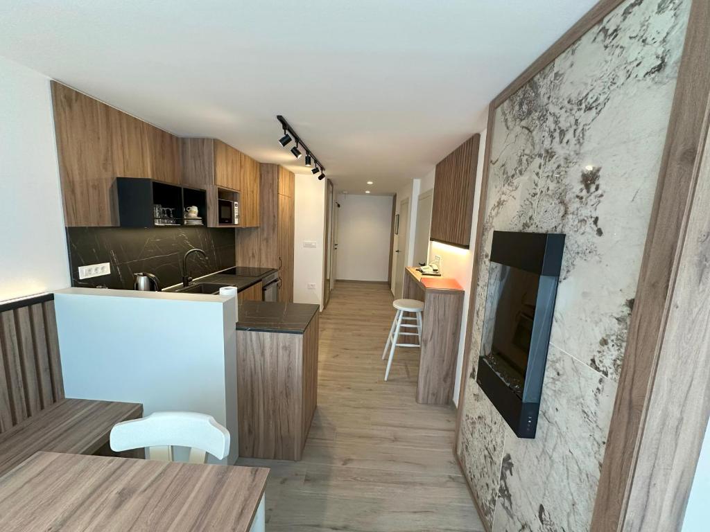 eine Küche und ein Wohnzimmer mit einer Theke und einem TV in der Unterkunft Žigon Bed & Breakfast in Logatec
