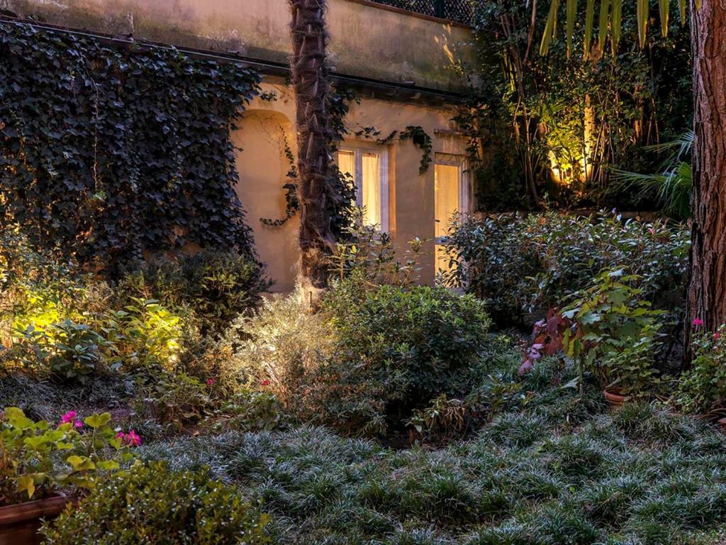 una casa vieja con un montón de plantas en un jardín en Dependance in giardino storico - Oltrarno, en Florencia