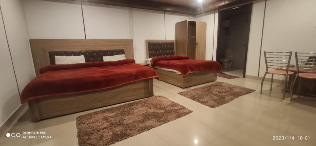 two beds in a room with rugs on the floor at Dhanolti Resort in Dhanaulti