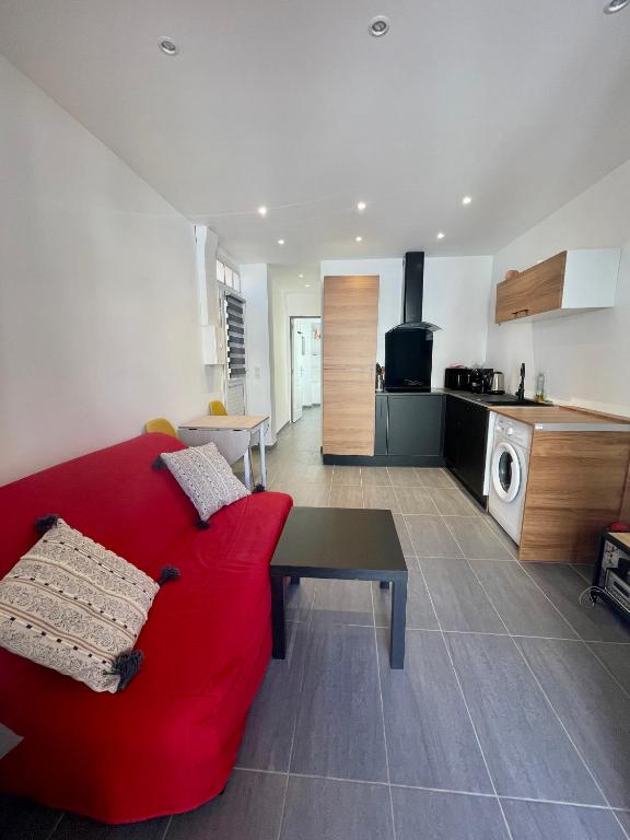 un salon avec un canapé rouge et une cuisine dans l'établissement Cosy appartement - Vieux port, à Antibes