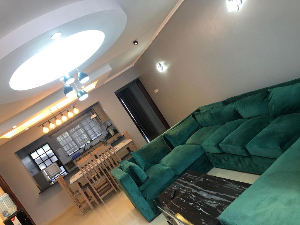 sala de estar con sofá verde y mesa en Nersheys 2 bedroom Apartment near Junction Mall, en Nairobi