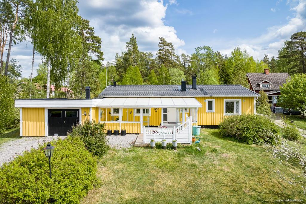 una casa amarilla con patio en 3BDR close to nature a beautiful home LAKE nearby en Uppsala