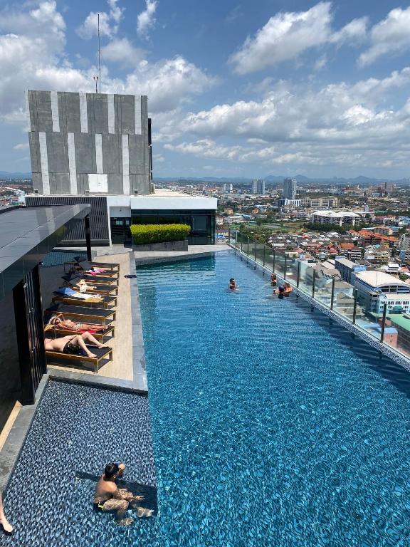 a pool on the roof of a building with people laying in it at The base in pattaya condo in Pattaya