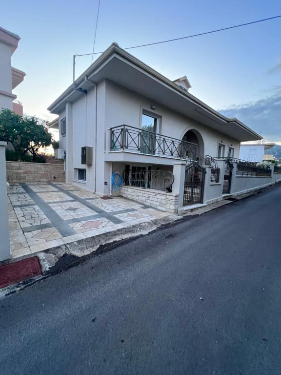 a white house on the side of a street at Άνετο διαμέρισμα 