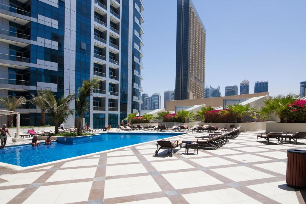 a pool in the middle of a city with tall buildings at Bay Central Tower in Dubai