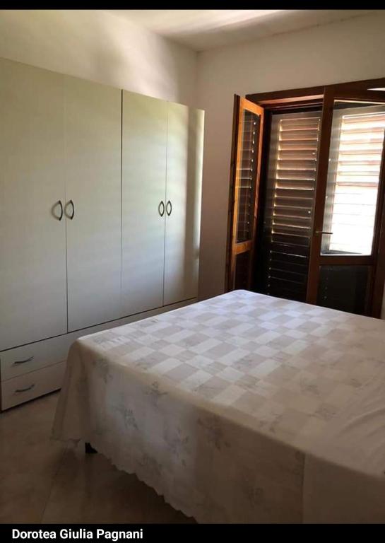um quarto com uma cama e armários e uma janela em Dorotea em Contursi Terme