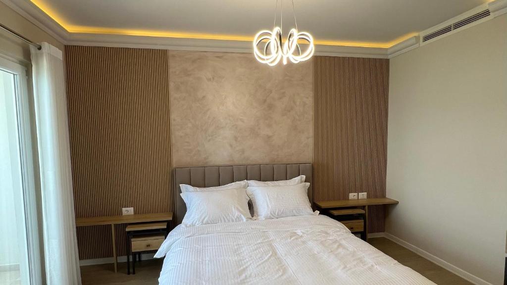 a bedroom with a bed and a chandelier at Hotel Demoli in Pogradec