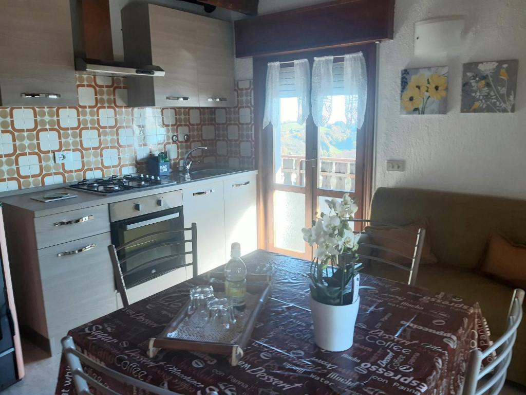 una pequeña cocina con mesa y mantel. en Mansarda accogliente a Lusiana en Lusiana
