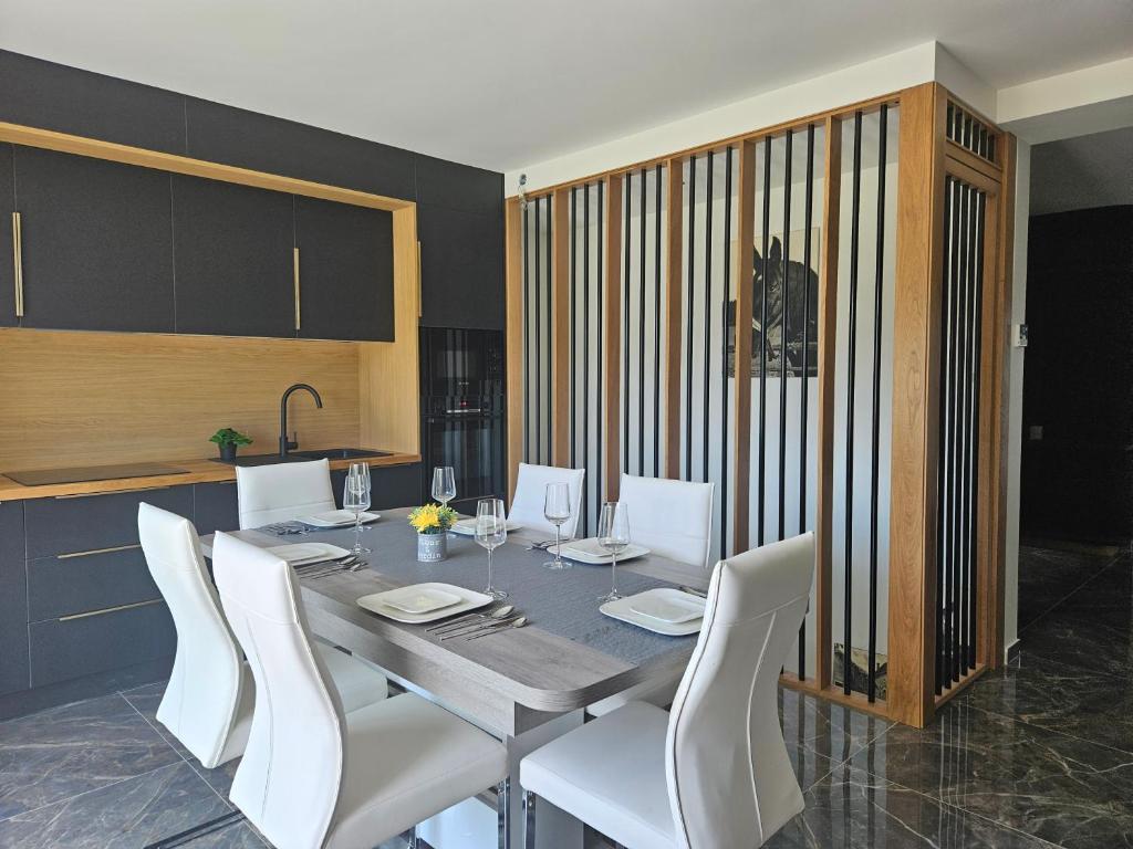 una sala da pranzo con tavolo e sedie bianche di Maison Paray- Orly- Parking Privé a Paray-Vieille-Poste