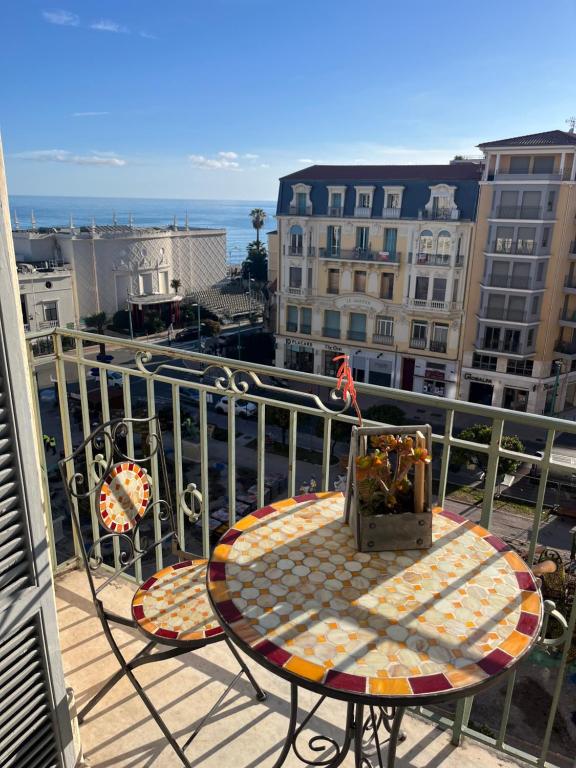 a table on a balcony with a view of the ocean at Menton centre Vue imprenable sur mer et jardin Biovès in Menton