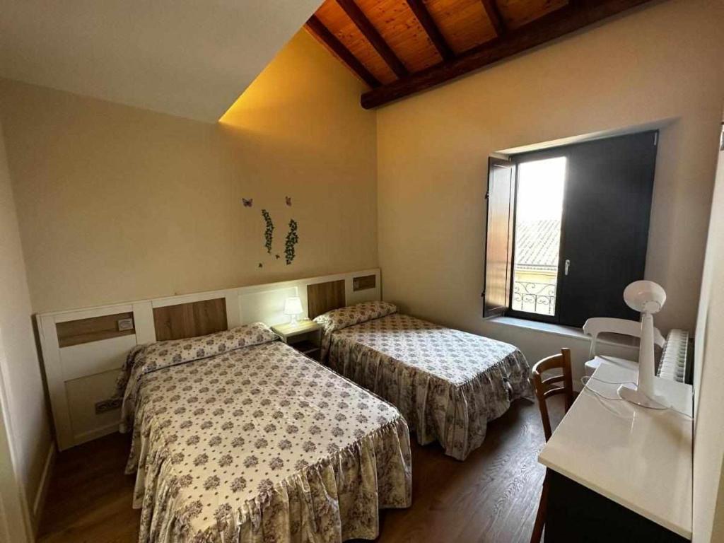 a hotel room with two beds and a window at Mati's Suite - San Torcuato 4 in Zamora