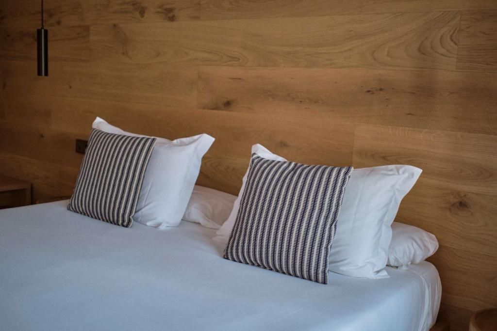 a bed with two pillows on top of it at Las Gaviotas Suites Hotel & Spa in Playa de Muro