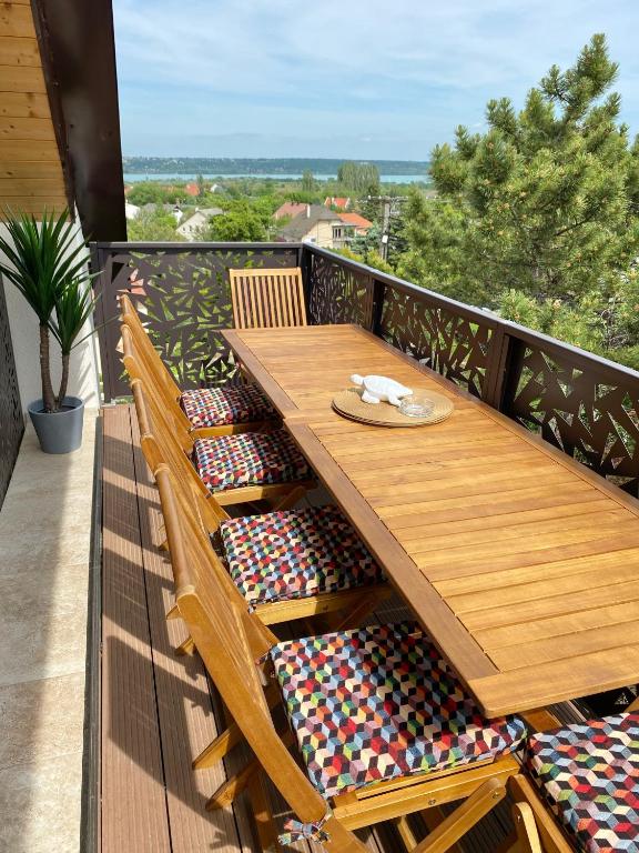 a wooden table and chairs on a balcony at Brisa Balaton in Balatonalmádi